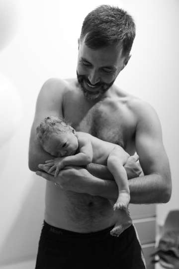 The pride of a father holding his newborn in a cozy early morning setting