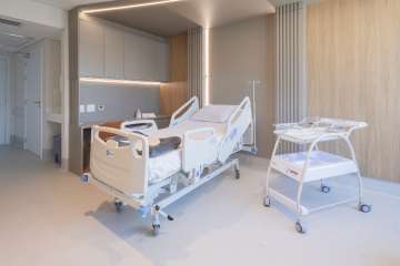 Patient room at Baía Sul Mulher: bed, seating area and equipment, Florianópolis
