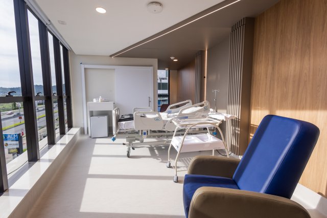 Patient room at Baía Sul Mulher: bed, seating area and equipment, Florianópolis